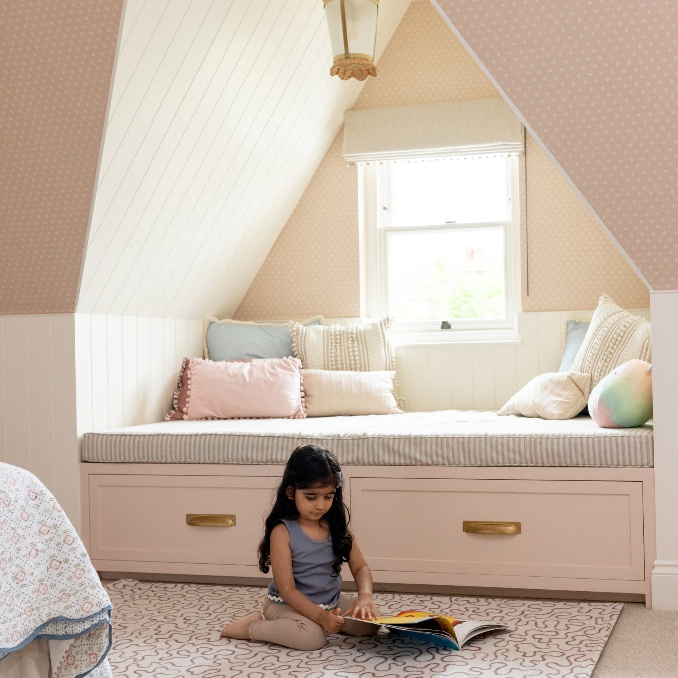 A child sits reading on a soft playmat in earthy tones