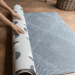 Hands unroll the double sided tapis de jeu for family floor play