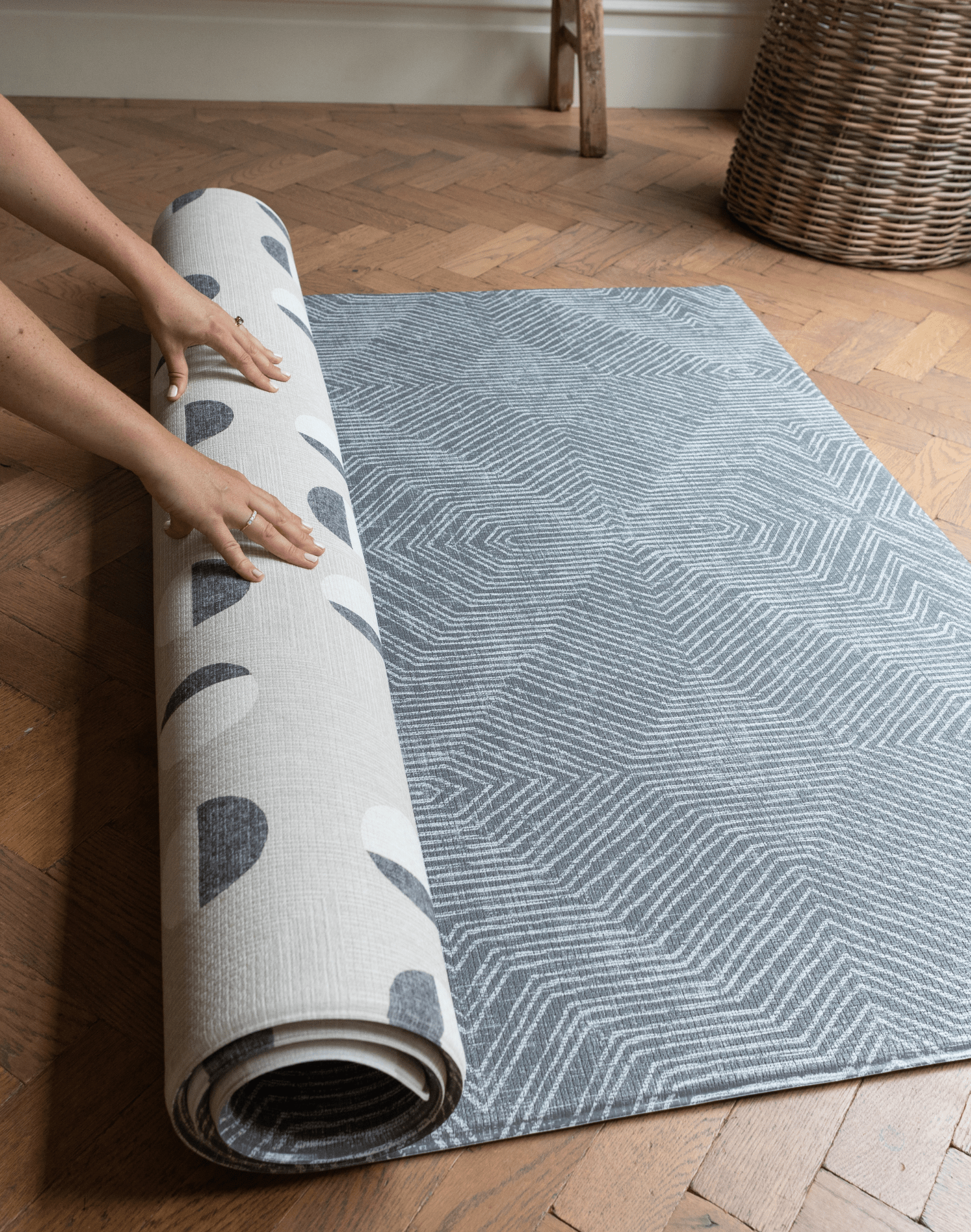 Hands unroll the double sided tapis de jeu for family floor play