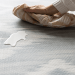 Milk spill being wipe away on Atlas blue and beige tumbling mat by totter and tumble for easy cleaning in the home