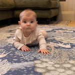 Baby enjoys tummy time on a Totter + Tumble luxury foam play mat in a William Morris motif. A non-toxic, stylish baby mat.