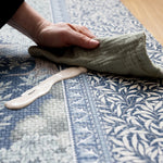 Detailed view of the durable Totter + Tumble nursery Brook play mat. A muslin cloth wipes up a spill on the playmat with ease