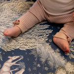 Close-up of baby’s legs on a Totter + Tumble woodland play mat; a safe foam play mat for lovers of premium baby products.
