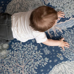 Bird’s-eye view of a baby exploring a William Morris decorative play mat - functional nursery decor meets elegant baby room.