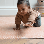 Little boy plays on crawling mat by totter and tumble with a modern orange design