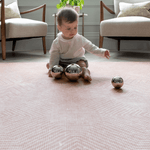 Little girl plays with sensory toys on the Totter and Tumble Tapis designed for safe play in the home