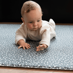 Baby enjoys tummy time on leopard print foam floor mat