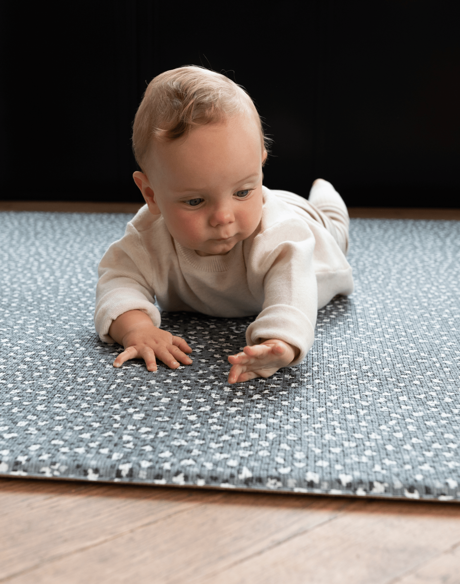Baby enjoys tummy time on leopard print foam floor mat