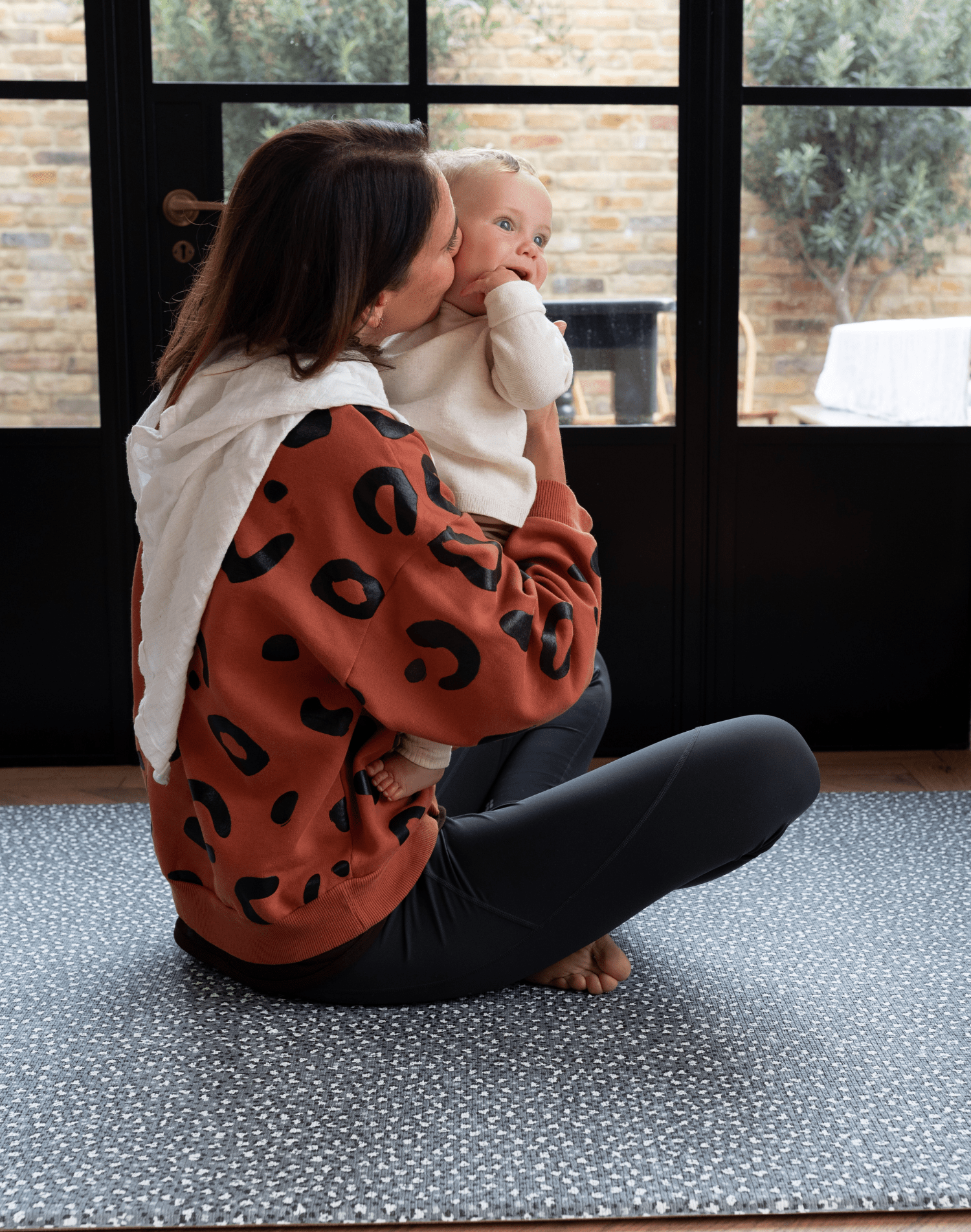 Lady and baby are protected on the thick padded floor mat by totter and tumble with a modern green design