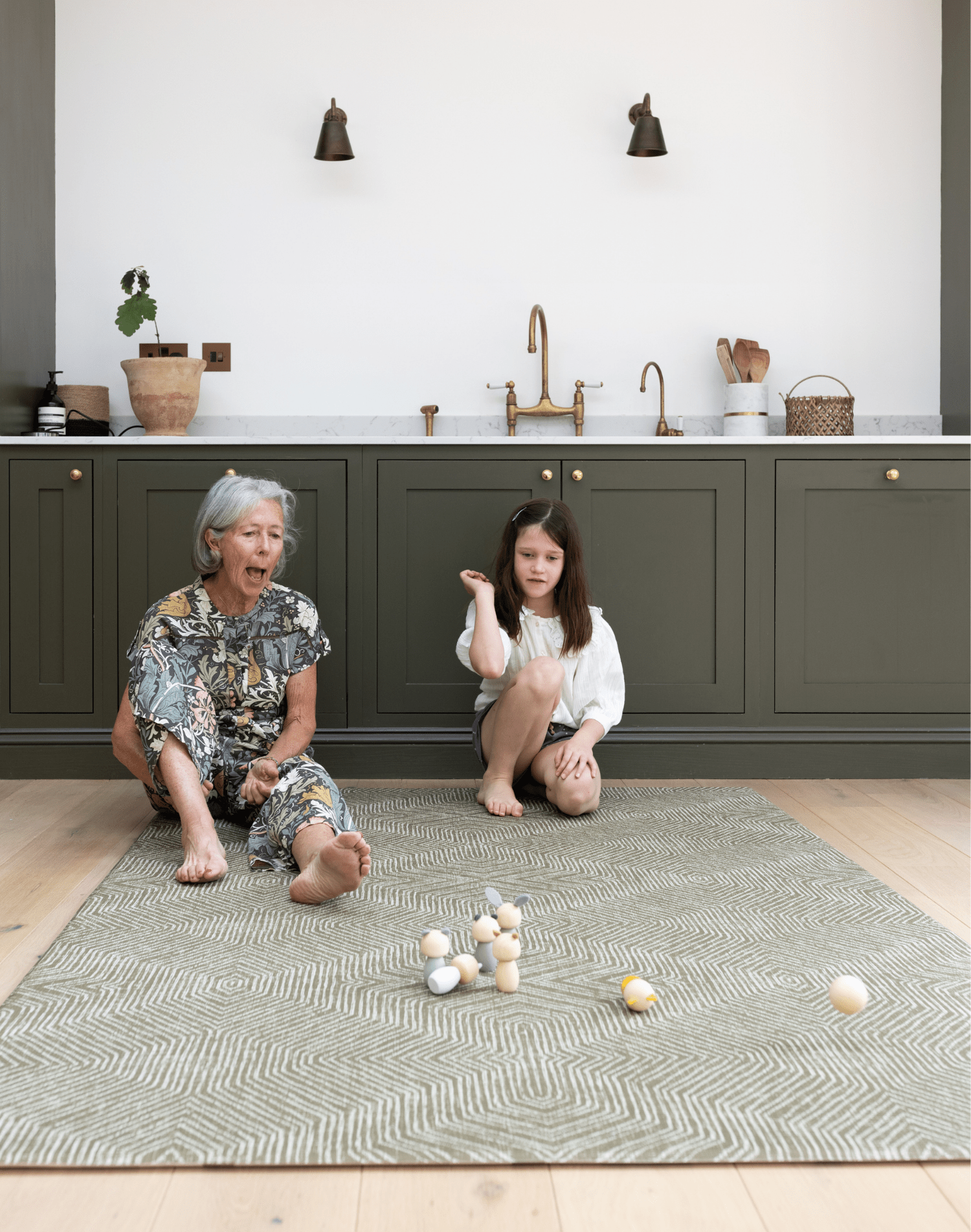 Lady and child enjoy play time together on the keuken mat in green tones to complement the kitchen