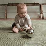 Cute baby enjoying sensory play on thick floor mat ideal for play time