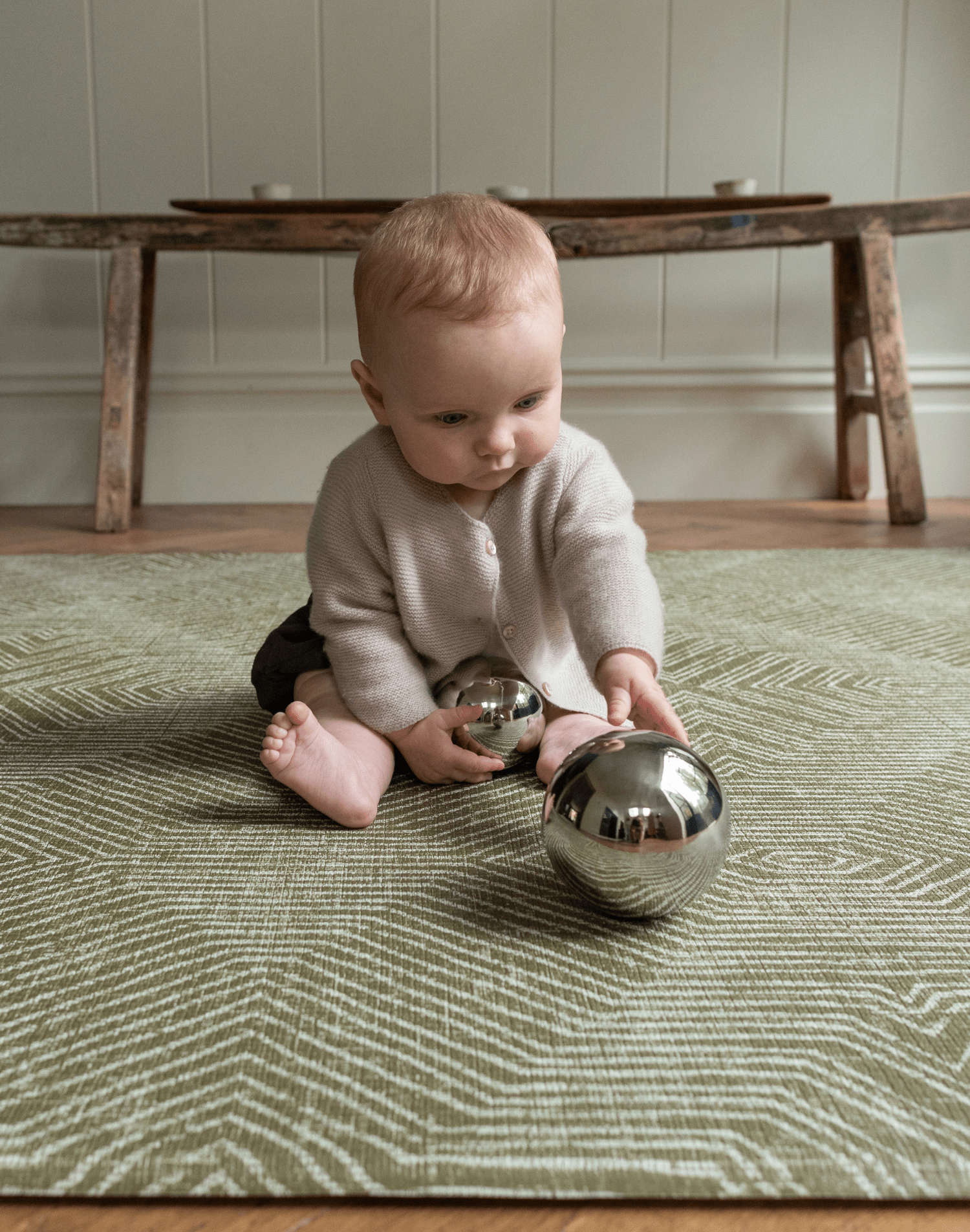 Cute baby enjoying sensory play on thick floor mat ideal for play time