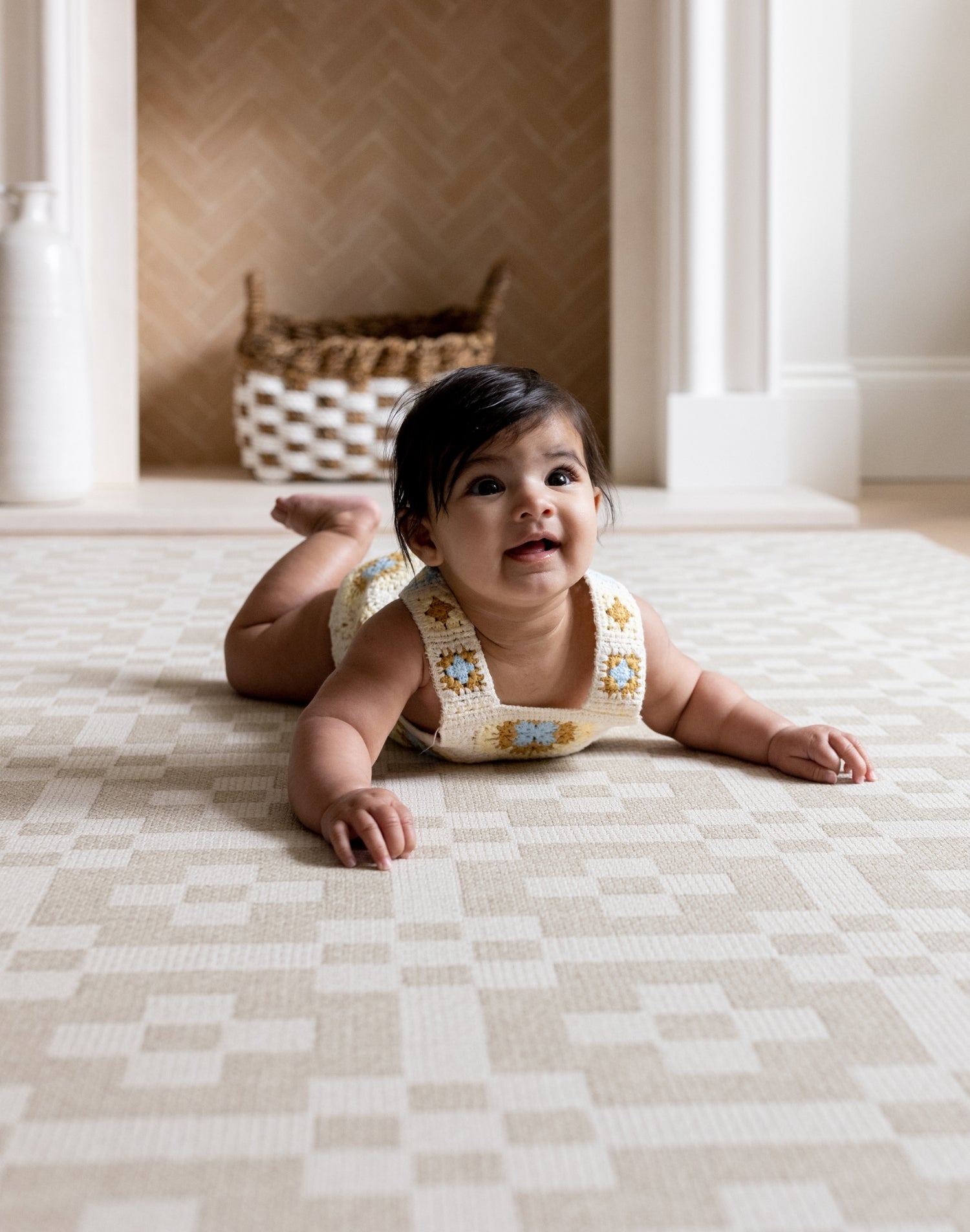 Toddler on The Holbein, a UK-designed baby mat in soft natural hues, perfect for tummy time or quiet play.