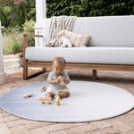Baby playing on padded round play mat on the patio enjoying floor play in comfort keeping body cool on hot tiles
