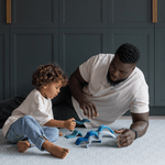 Man and boy playing on scalloped Mariner design play mat keeping comfortable on the memory foam and enjoying open play wooden toys