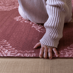 Baby crawls across thick memory foam mat with beautiful textural design a play mat that looks like a rug while protecting babies and adults on the floor