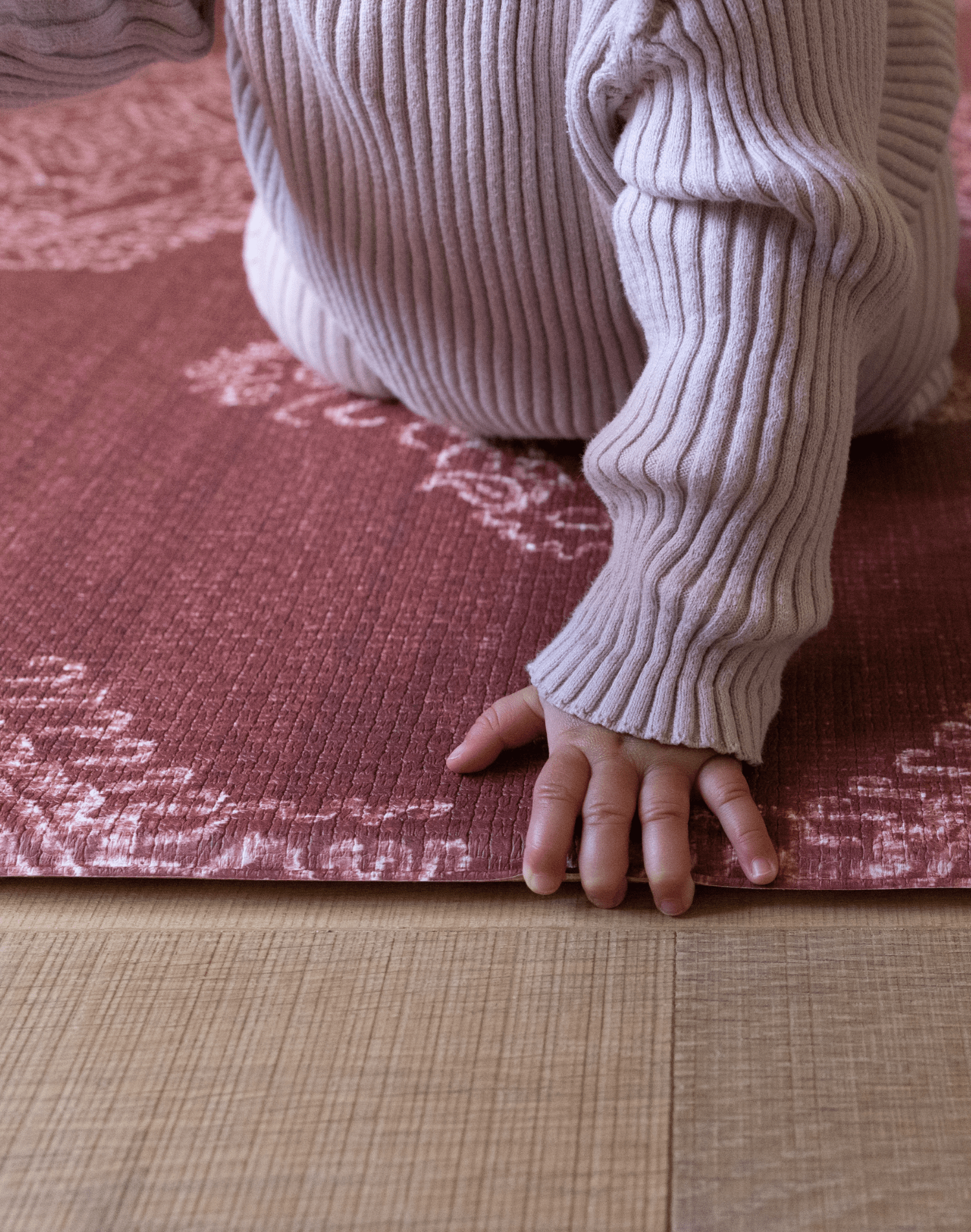Baby crawls across thick memory foam mat with beautiful textural design a play mat that looks like a rug while protecting babies and adults on the floor