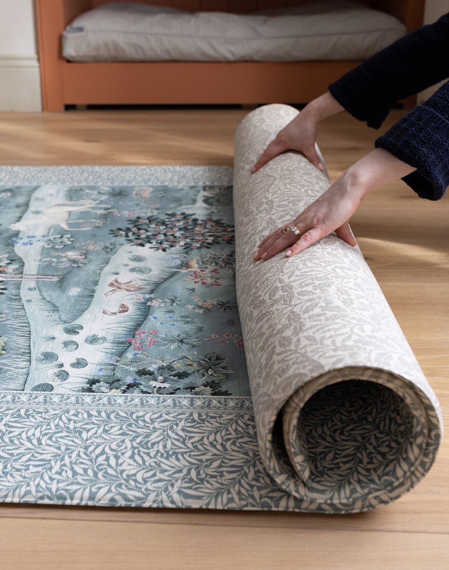 Unrolling a luxury foam play mat from the Totter + Tumble x Morris & Co. collaboration that is durable, easy-to-clean, and ideal for lovers of nature-inspired motifs in the nursery or playroom
