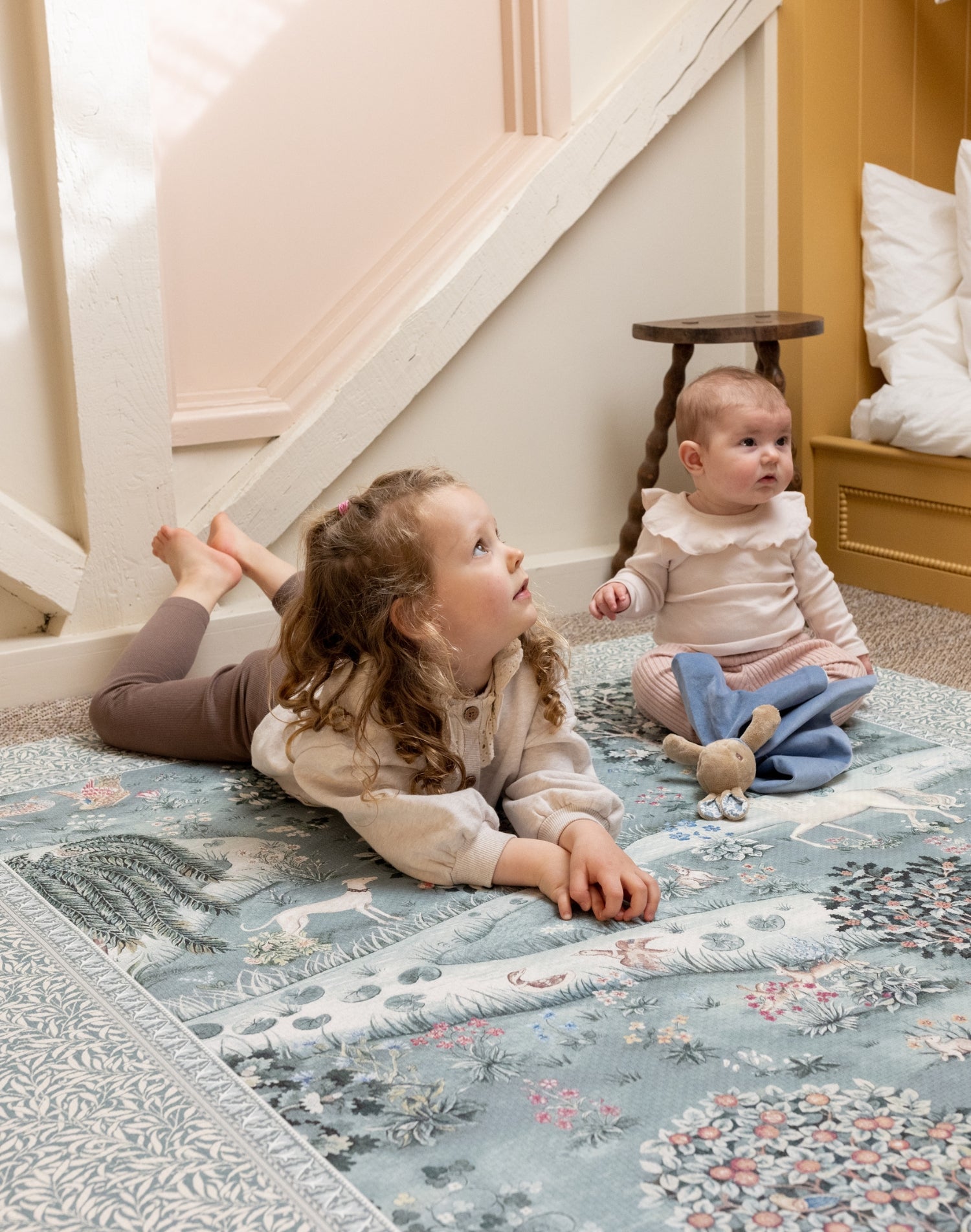 Two children playing on a Totter + Tumble luxury play mat, perfect for high-end baby accessories in compact spaces.