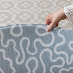 Lifting The Pembroke and Holbein, a designer playmat with textured surface, to reveal the reverse design