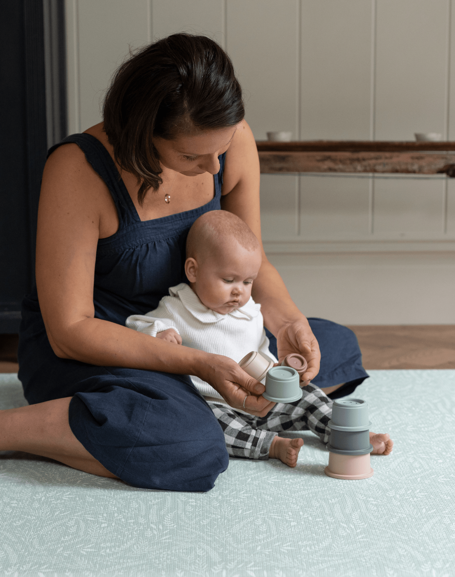 Mother and baby explore stacking cups on the groente speelmat that offers support and is extra comfortable