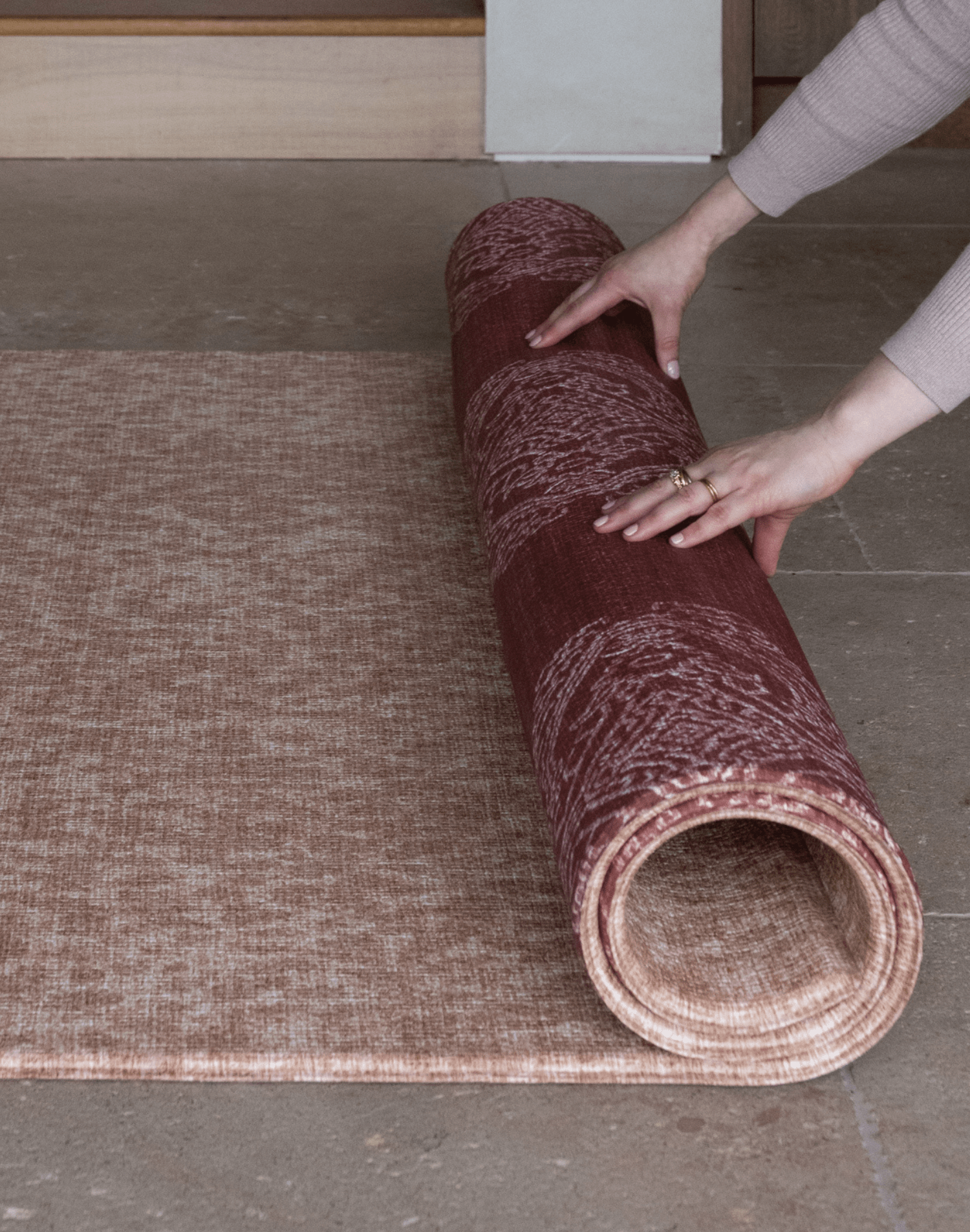 Unrolling double sided red and tan play mat made with thick padded memory foam for ultimate support on tiled flooring