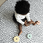 Baby explored wooden eco toy on the allergy friendly baby mat by totter and tumble