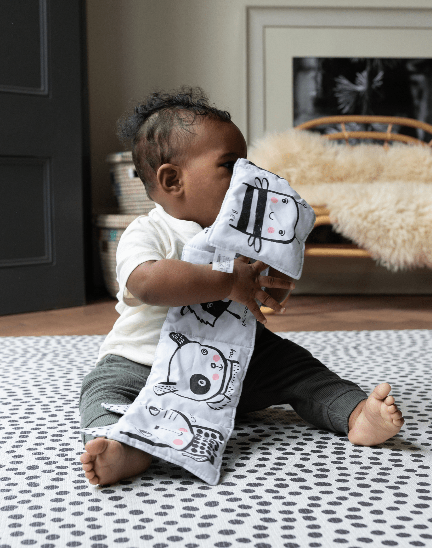 Baby enjoys play time on supportive groot speelmatten with black ad white design
