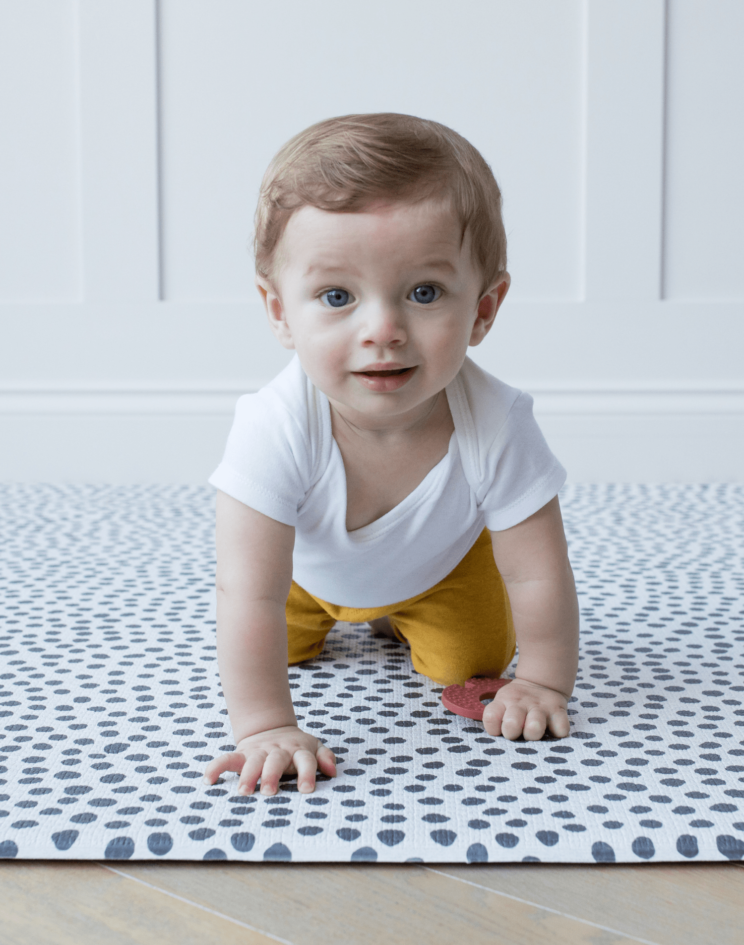 Little baby crawls across crawling mat with textured surface for traction while moving