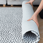 Hands unroll an ultra-thick memory foam baby play mat designed for extra comfort and support