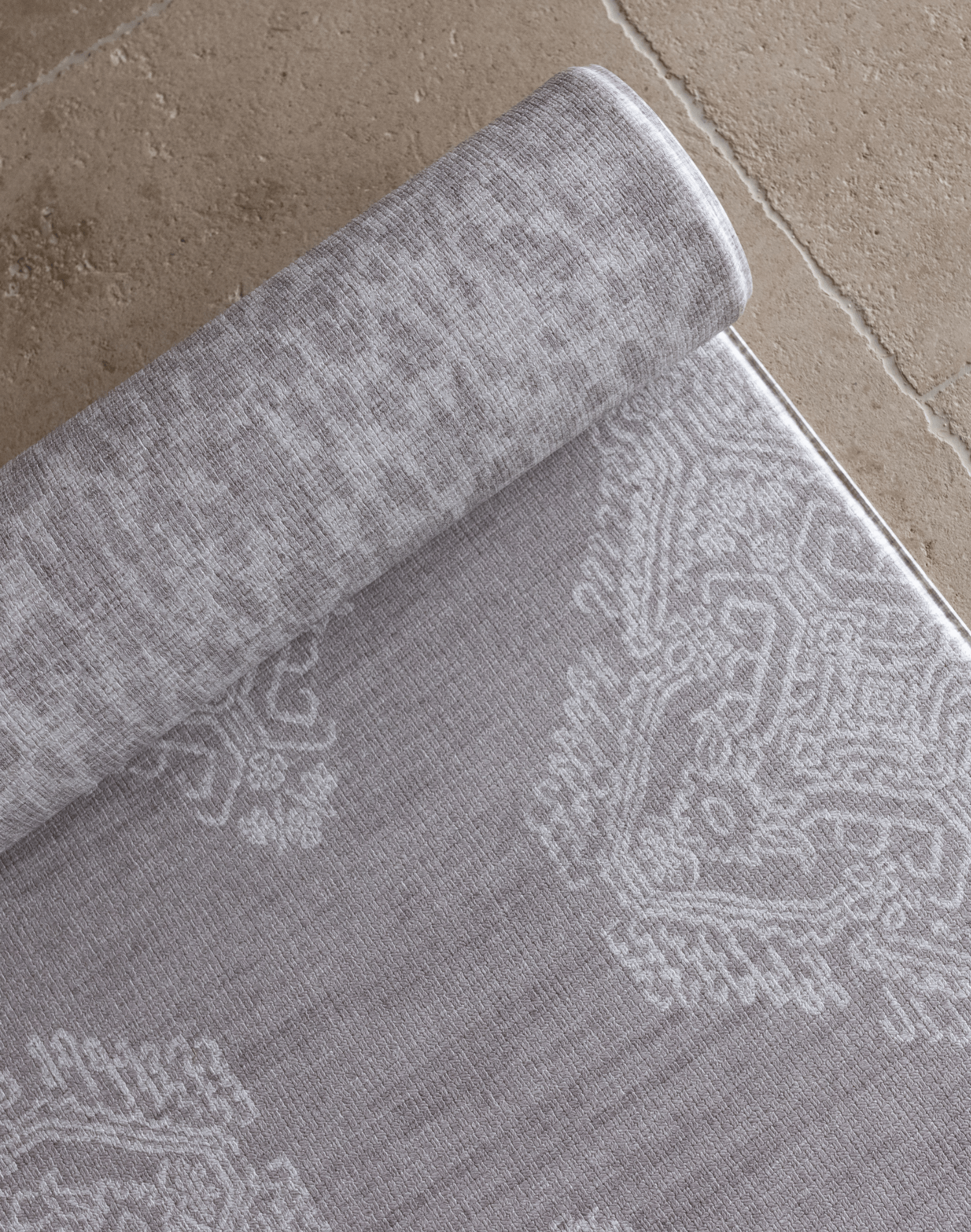 Close up of the Soft grey playmat design the sepi by totter and tumble with a batik inspired textile effect to look like a rug in the home playmats for family homes available in four sizes