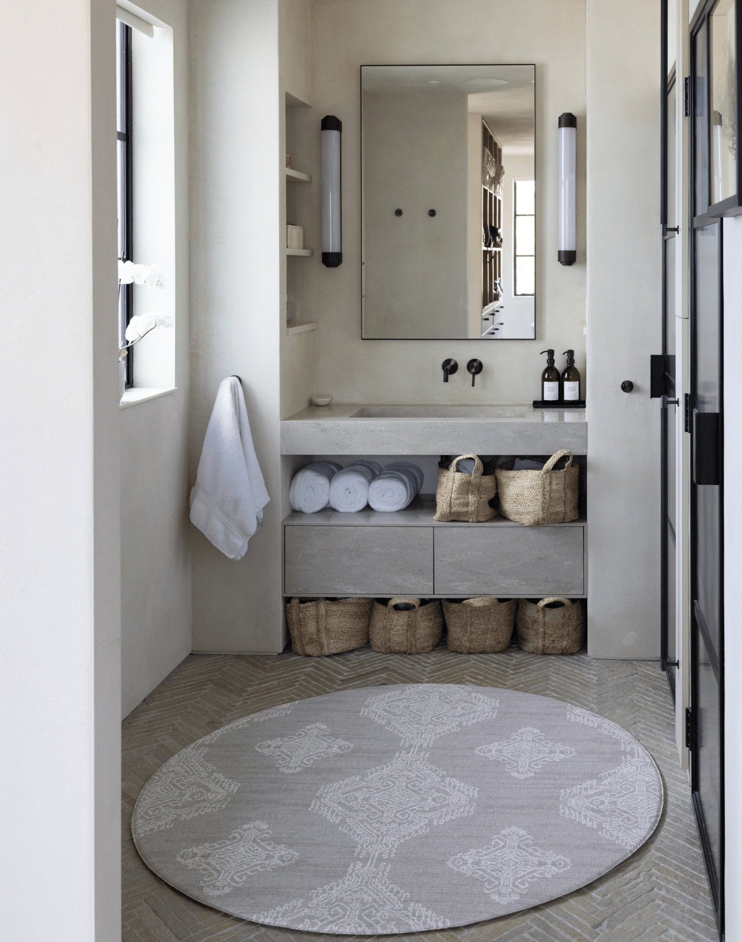 Large round waterproof playmat unrolled in bathroom space to add protection on the floor and allow for comfier changing time