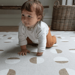 Baby is supported on thick Spelmatta with durable memory foam and organic polka design