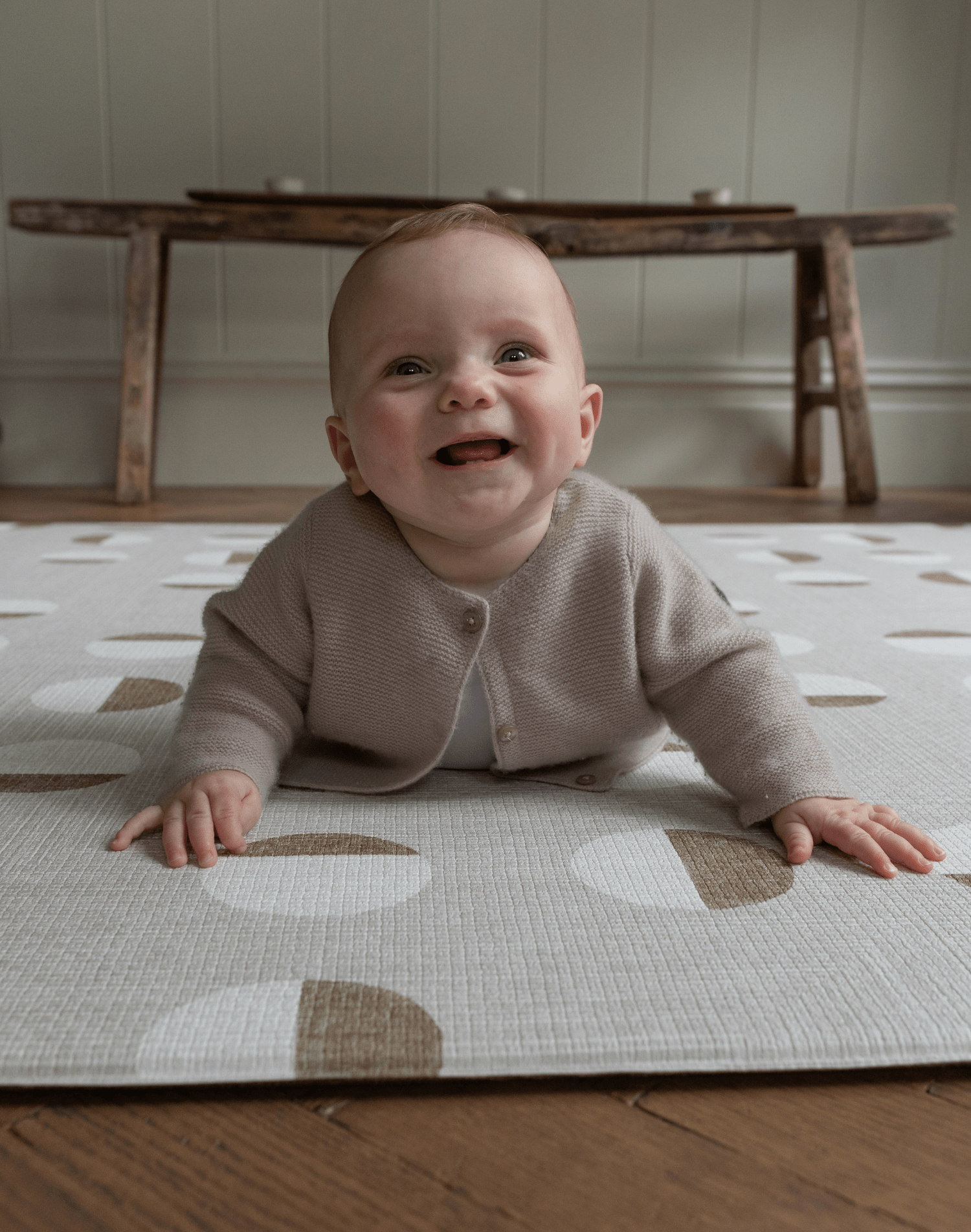 Happy baby enjoys tummy time on baby play mat with durable supportive design