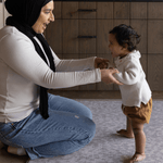 Mum and baby enjoy floor time together on the comfortable grey playmat by totter and tumble the sunda with delicate animal print play mat design that looks stylish in the family home with luxury memory to support the whole family