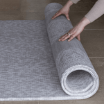 Hands roll out the reversible grey play mat by totter and tumble with two complementary grey designs for family homes and thick memory foam for comfy floor time activities