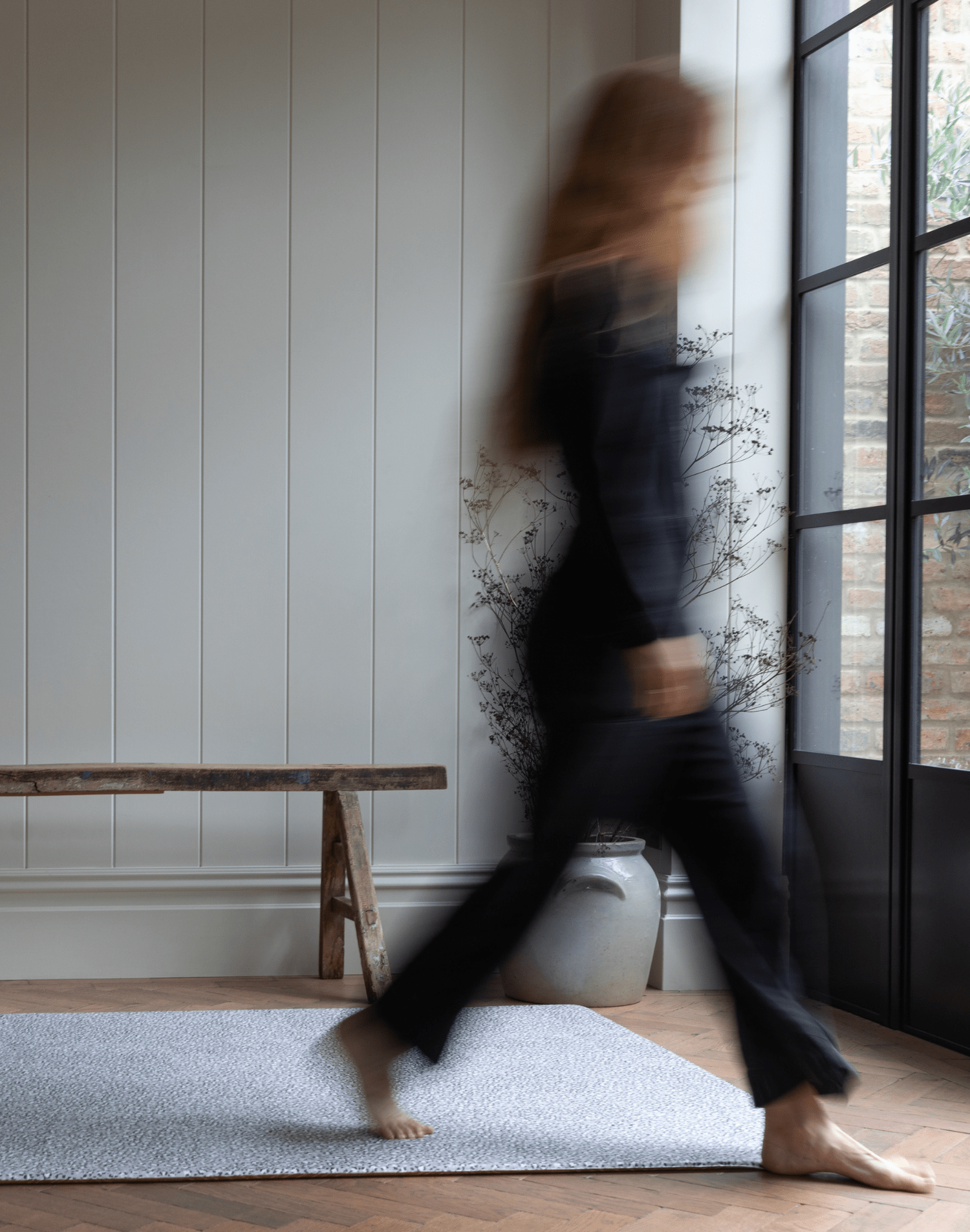 Lady walks across padded baby foam mat with grey leopard print motif that is subtle for the space