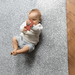 Baby plays on soft foam mat with textured teething toy
