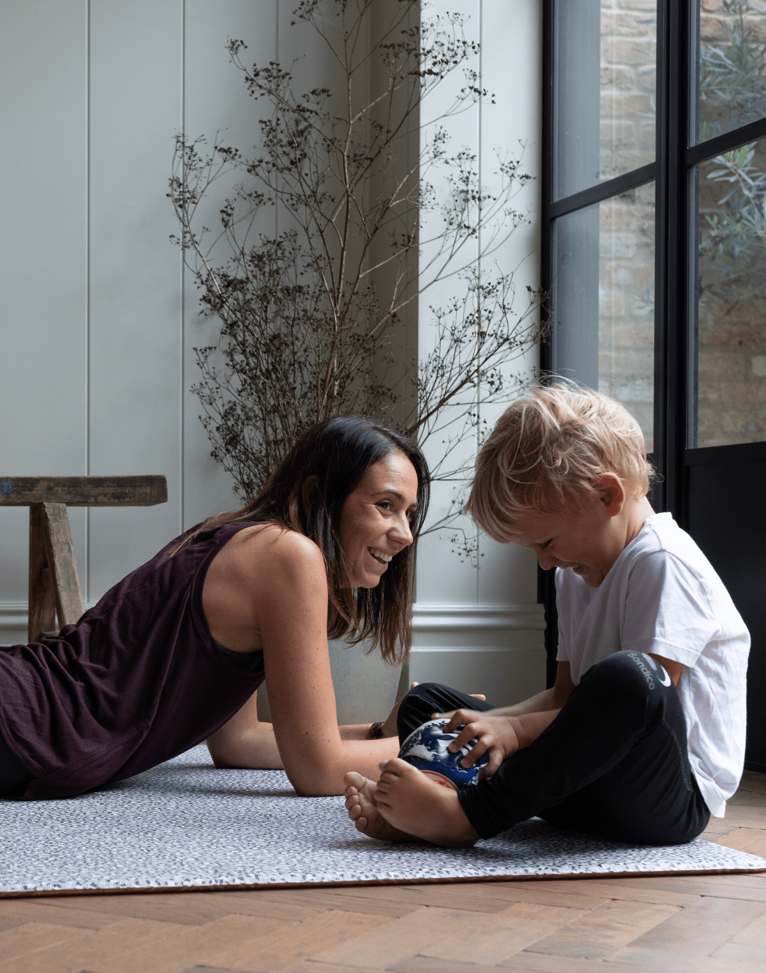Mother and son enjoy time on the floor together protected on comfortabel spelmatta