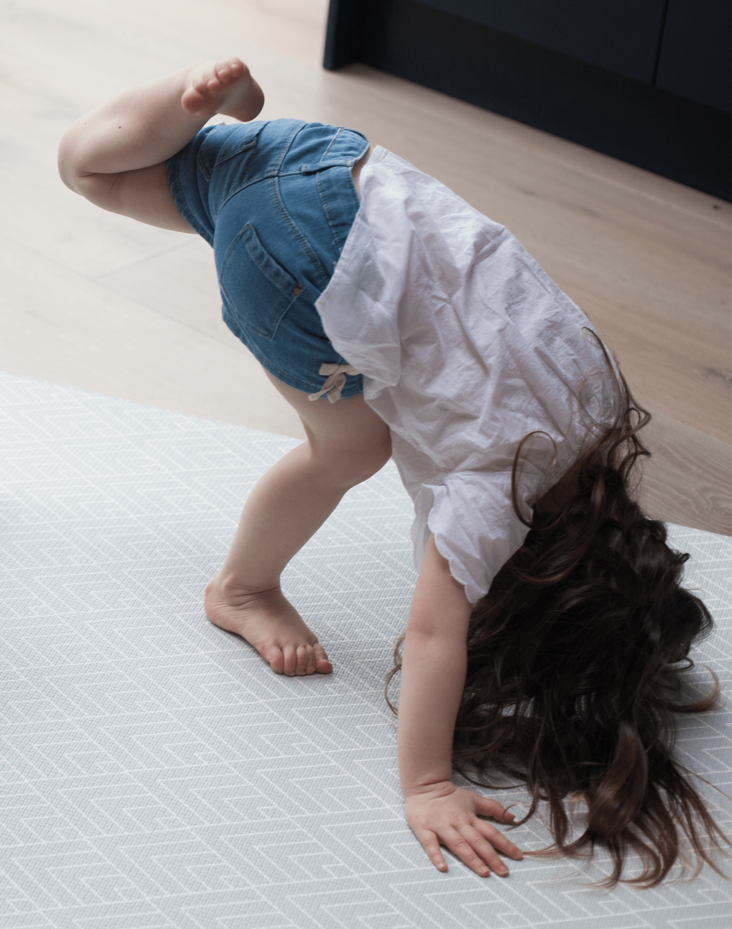 Little girl exercises on large non-slip play mat