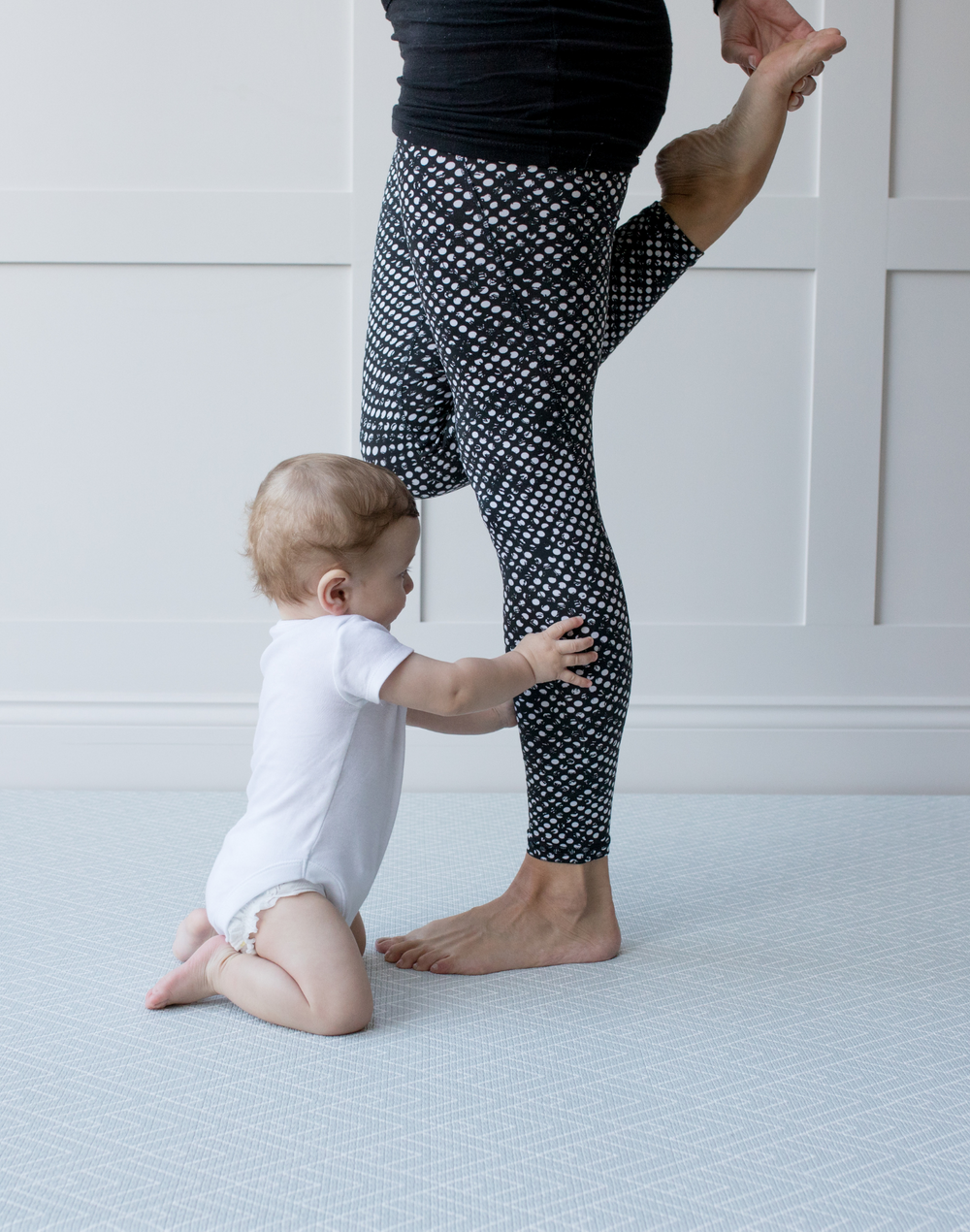 Baby reaches for mums legs on extra large yoga mat with wanderer design by totter and tumble 