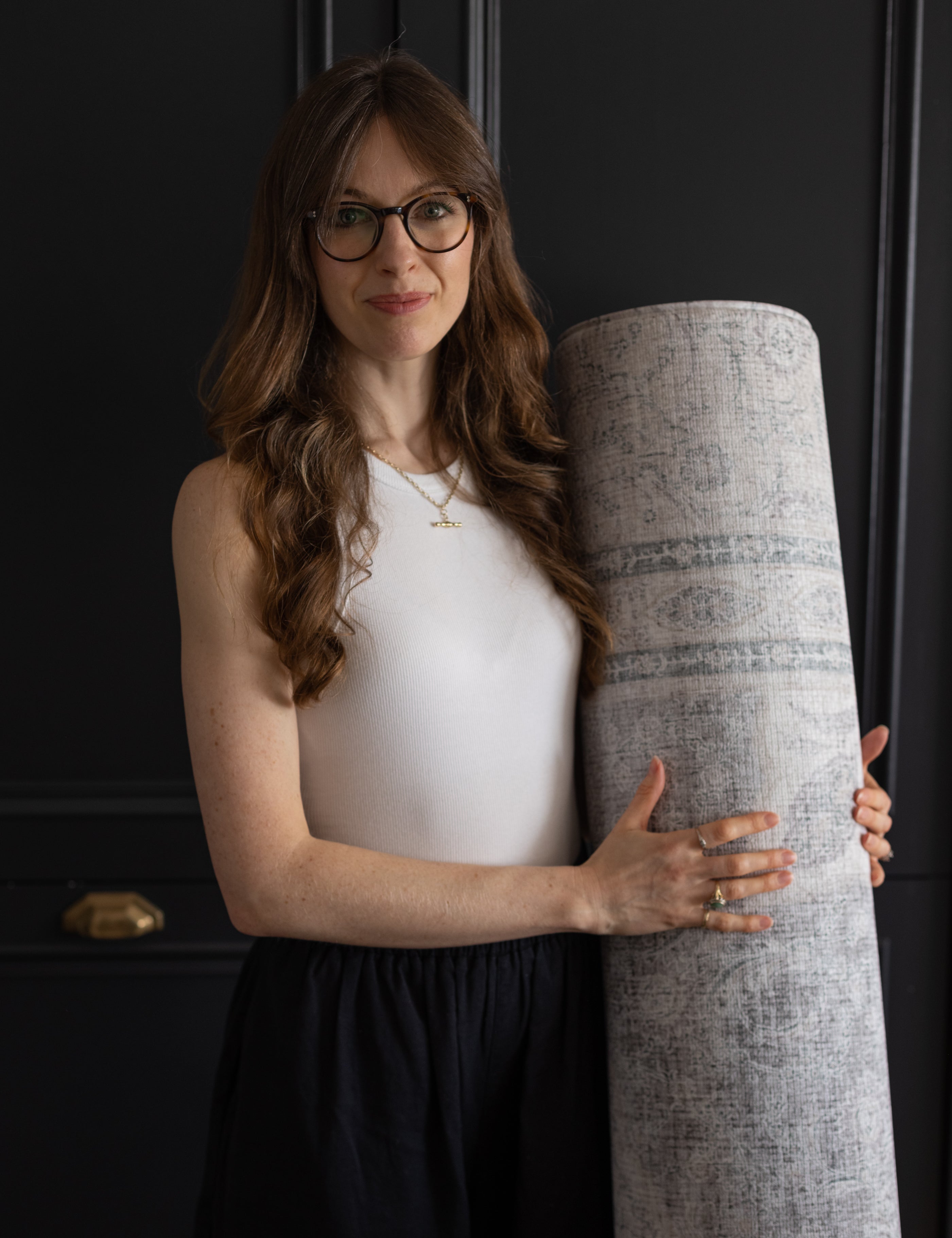 Totter + Tumble designer with a rolled rug play mat