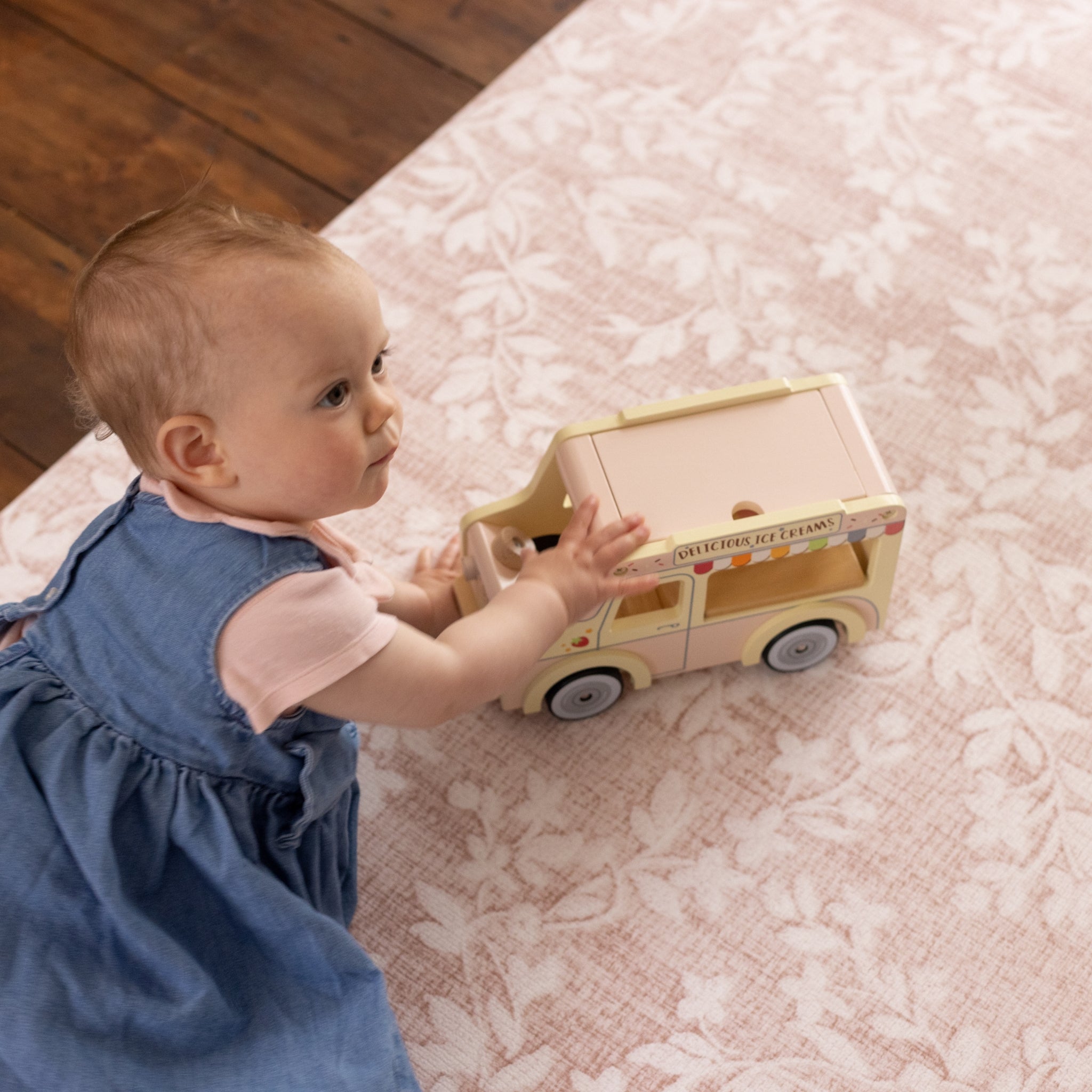 Baby playing on a non toxic floral pink playmat from totter and tumble