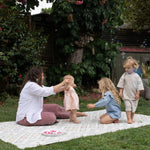 Woman and children playing outdoors on a memory foam kids playmat.