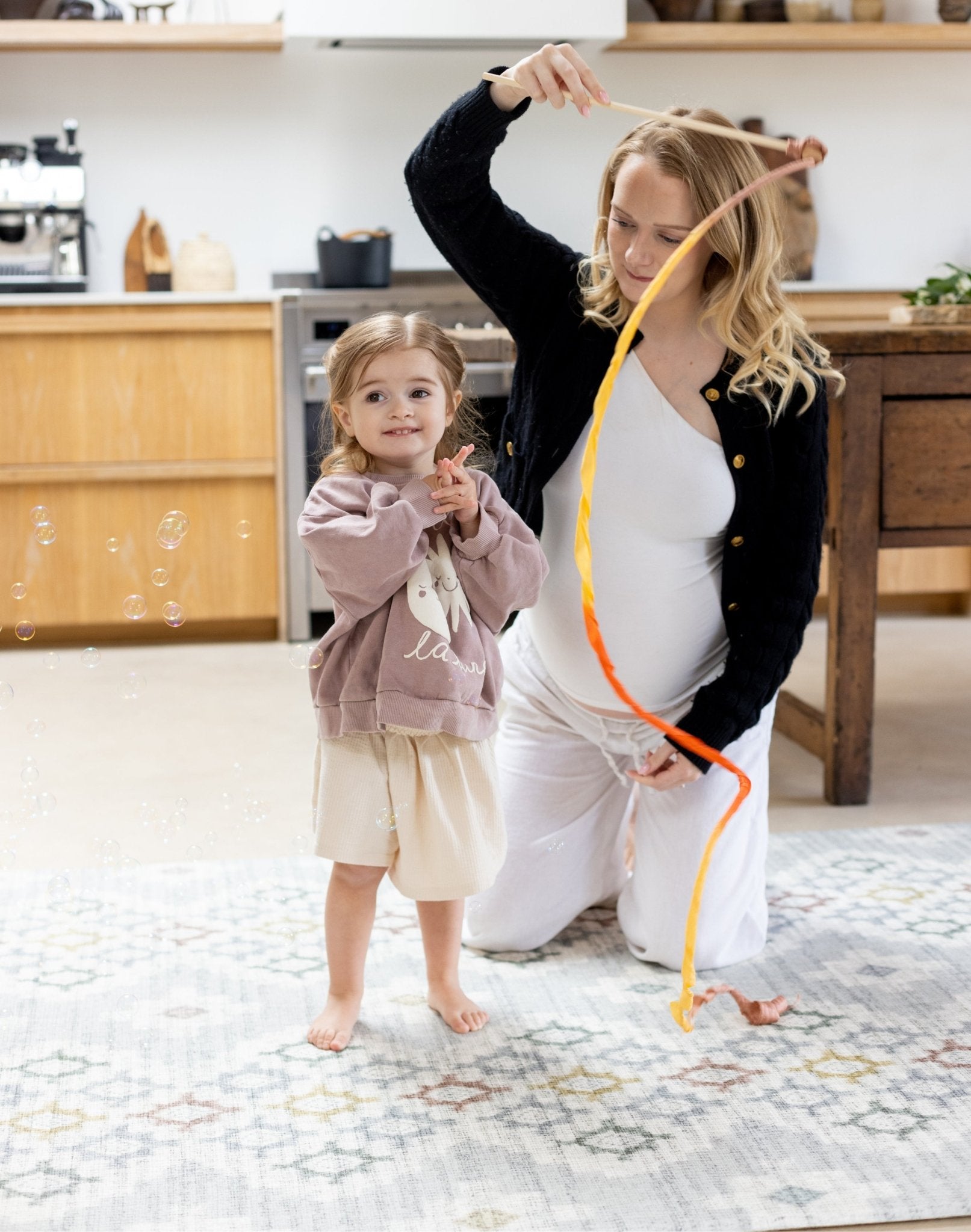 Woman and child playing on a designer baby play mat that matches home decor