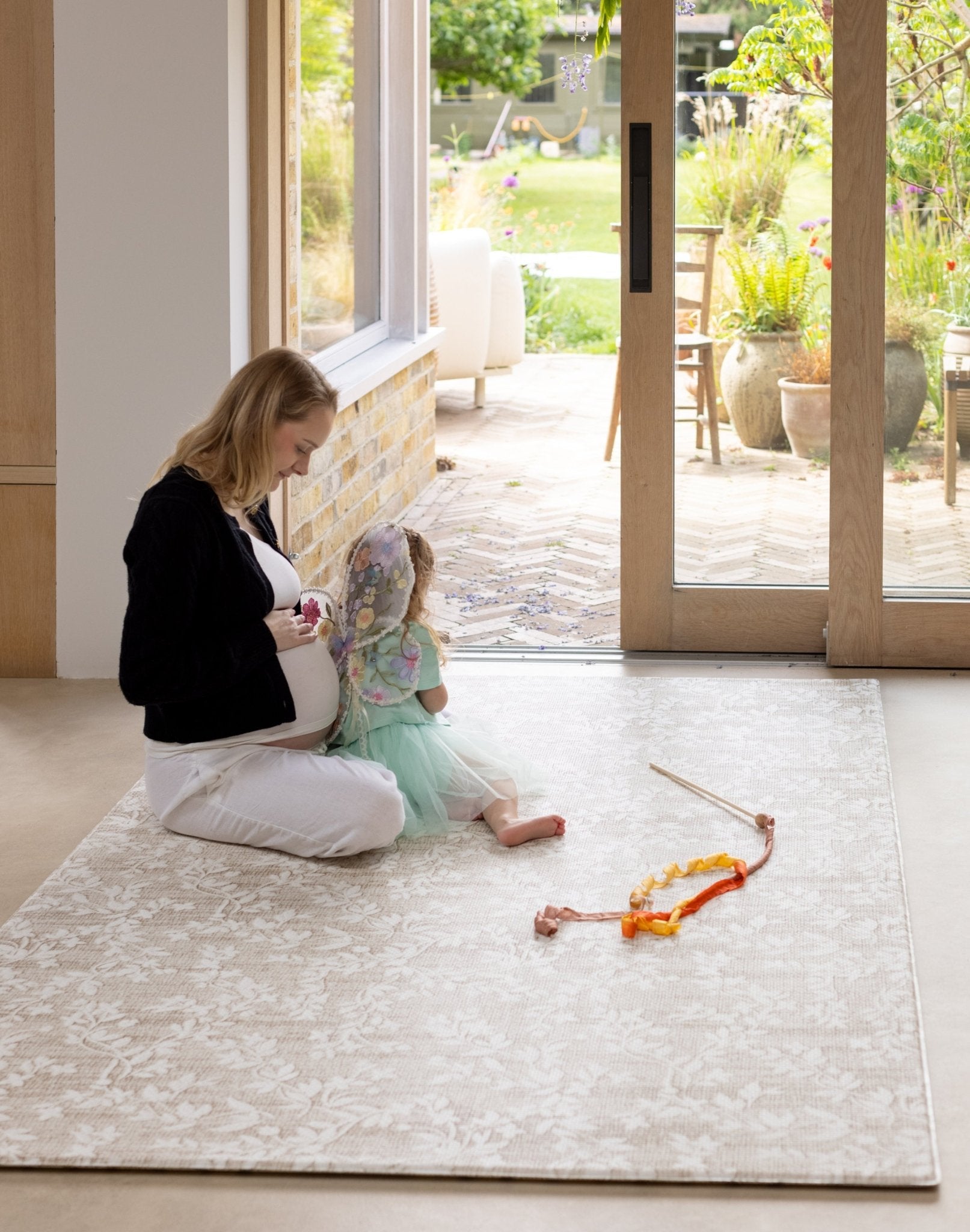 Woman and child playing on a floral botanical baby play mat for hardwood floors
