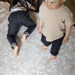 Two children on a floral designer play mat for living room