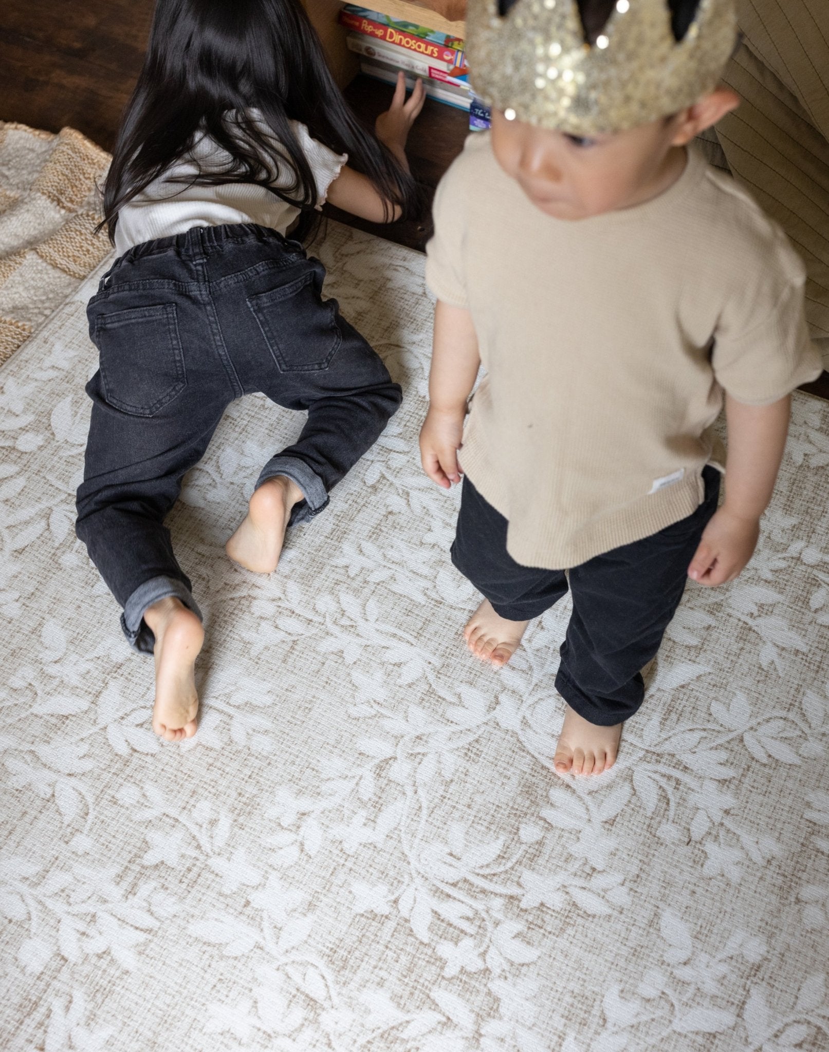 Two children on a floral designer play mat for living room