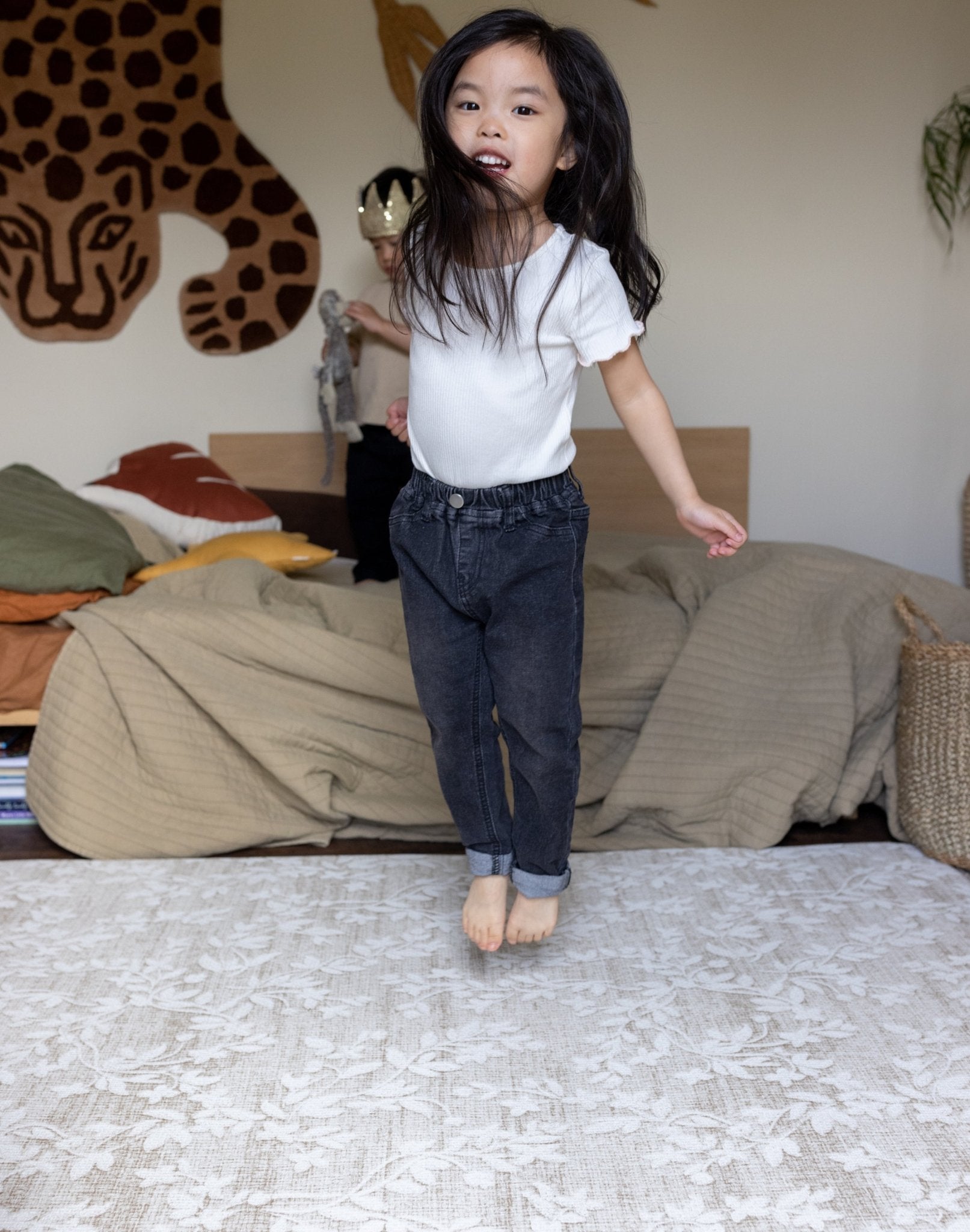 Child jumping on a luxury foam play mat that blends into living room decor