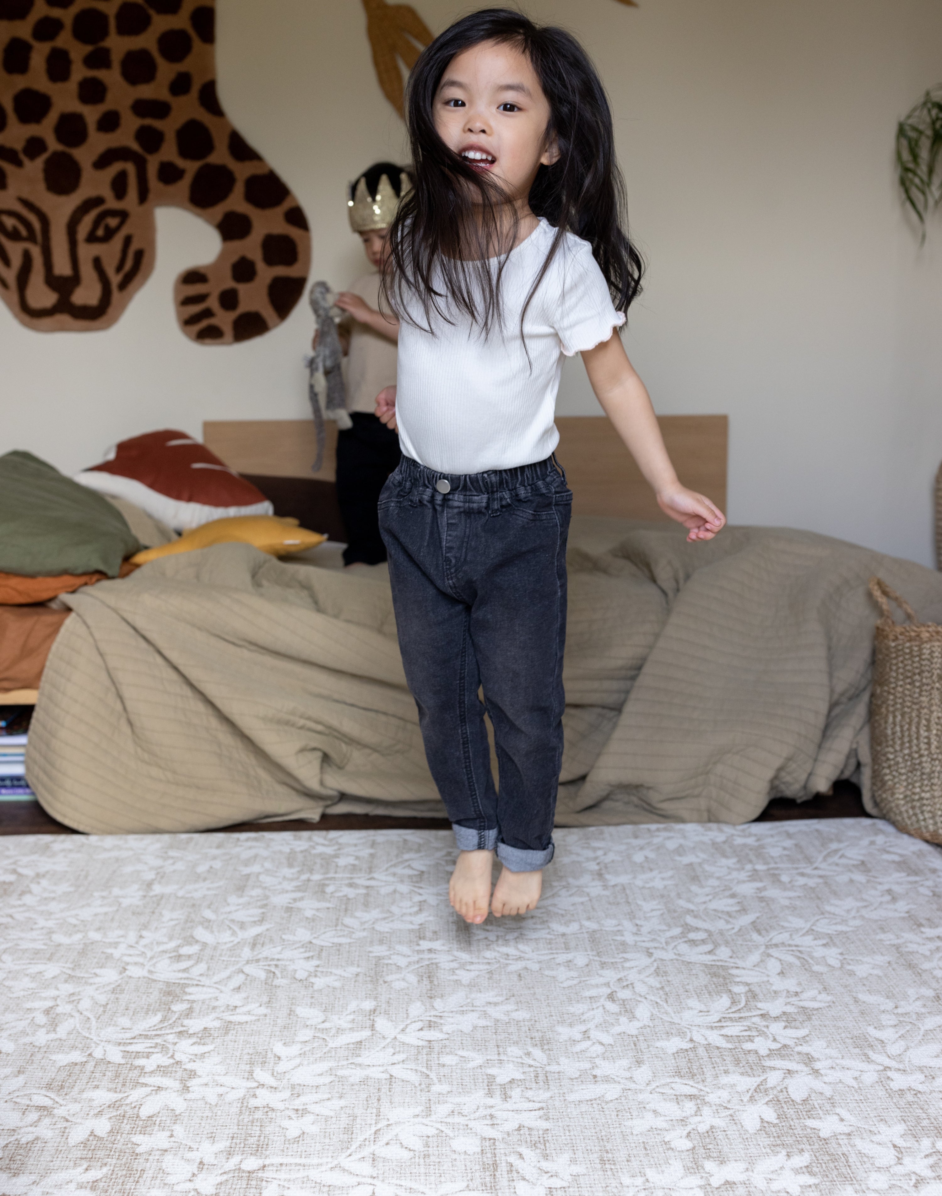 Child jumping on a luxury foam play mat that blends into living room decor